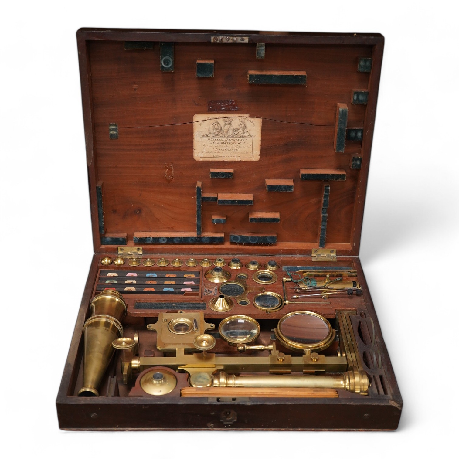 A mid 19th century folding compound and simple monocular microscope by William Harris & Co. 50 High Holborn, London, in its fitted mahogany case with paper maker’s label to inside of the lid. Condition - fair to good, so